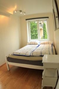 a small bed in a room with a window at Apartment Bystranda - City Beach in Kristiansand