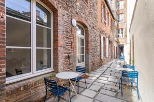 un patio avec des tables et des chaises à côté d'un bâtiment dans l'établissement LA COUR DES CARMÉLITES 2 - Studio calme en centre-ville, à Rennes