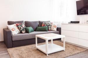 sala de estar con sofá y mesa de centro blanca en Marcowy en Sopot