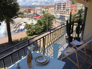 a balcony with a table and a view of a city at I love Nice - FACE MER, DESIGN, TERRASSE, ASC, WIFI, CLIM in Nice