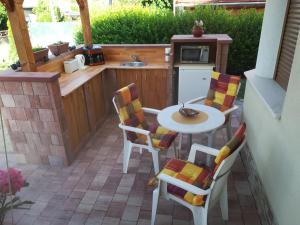 a small kitchen with a table and chairs on a patio at Betty Apartman in Balatonfůzfő