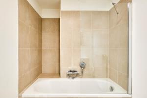 een bad met een kraan in de badkamer bij Diamant 1BR in Brussel