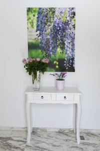 uma mesa branca com dois vasos de flores em Il Glicine em Marsala