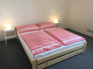 a bed with pink blankets and pillows on it at Penzion Na Vyhlídce in Frýdlant nad Ostravicí