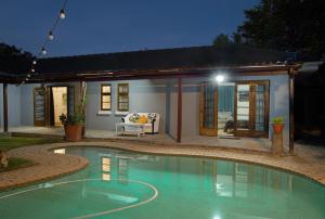 a swimming pool in front of a house at night at The Walmer Oasis in Port Elizabeth
