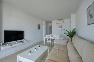 un salon blanc avec un canapé et une table dans l'établissement Barrosa Frente al Mar, à Chiclana de la Frontera