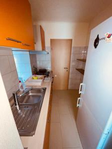 a small kitchen with a sink and a refrigerator at Blue Sky in Koper