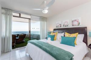 1 dormitorio con 1 cama y vistas al océano en Sands Beach Breaks Umdloti Luxury Beach Front, en Umdloti