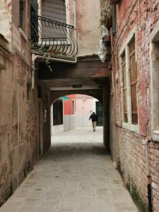 an alley way with a person walking down it at Ca Cristallina in Venice