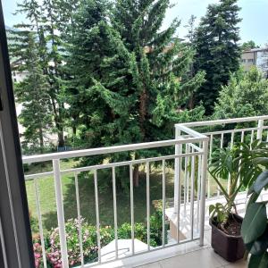 Elle comprend un balcon avec une balustrade blanche et des arbres. dans l'établissement Apartments Smakoski, à Ohrid