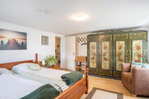 a bedroom with a large bed and a chair at Ferienhaus Carin in Utting