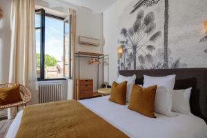 sypialnia z dużym łóżkiem i oknem w obiekcie Hôtel La Résidence w mieście Narbona