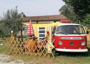 een rood-wit busje geparkeerd voor een huis bij MES NUITS VINTAGE EN COMBI in Robion en Luberon