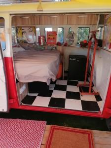 een kamer met een bed en een geruite vloer in een busje bij MES NUITS VINTAGE EN COMBI in Robion en Luberon