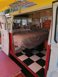 een bed achterin een busje met een geruite vloer bij MES NUITS VINTAGE EN COMBI in Robion en Luberon