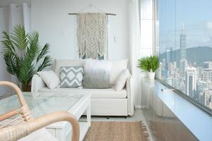 sala de estar con sofá blanco y mesa de cristal en urban abode apartments, en Taipéi