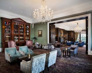 uma sala de estar com cadeiras e um lustre em Oulton Hall Hotel, Spa & Golf Resort em Leeds