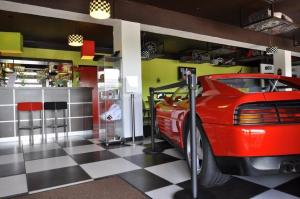 a garage with a red car and a checkered floor at Enzo Hotels Vierzon by Kyriad Direct in Vierzon