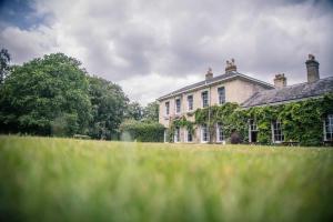 uma grande casa branca com hera a crescer nela em Caistor Hall em Norwich