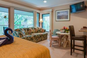 a bedroom with a bed and a living room at Hale Napili in Lahaina