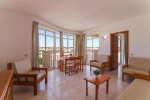 a living room with a table and chairs and windows at Oura 9ºa in Armação de Pêra