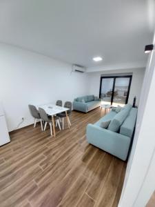 uma sala de estar com dois sofás azuis e uma mesa em Apartmani Aida em Dobra Voda