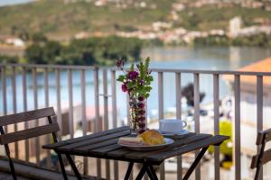 uma mesa com um vaso de flores e um prato de comida em Imperio Hotel em Peso da Régua