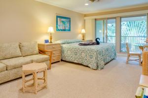 a bedroom with a bed and a couch at Hale Napili in Lahaina