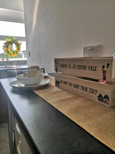 a kitchen counter with a table with plates on it at Au Centre-Ville in Lisnaskea