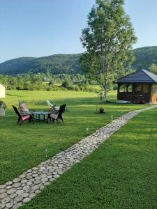 a park with a table and chairs and a gazebo at Apartments Paradise in Ličko Petrovo Selo