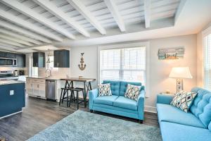 a living room with two blue chairs and a kitchen at Modern Oak Island Escape 1 Mile to Long Beach! in Oak Island