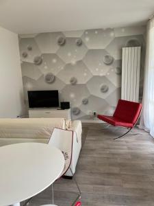 ein Wohnzimmer mit einem Sofa und einem roten Stuhl in der Unterkunft casa vacanze esmeralda in Zanica