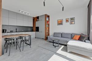 a living room with a couch and a table at Dom & House - Apartments Nadmorski Park in Gdańsk