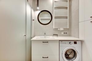 a bathroom with a washing machine and a sink at Dom & House - Apartments Nadmorski Park in Gdańsk