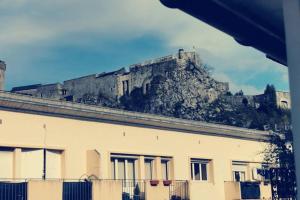 a castle on top of a hill behind a building at Location G&W, très proche sanctuaires II in Lourdes
