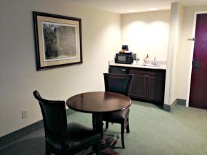 a room with a table and chairs and a kitchen at Wingate by Wyndham Charleston Southern University in Charleston