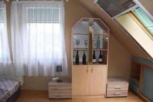 a room with a shelf with bottles of wine at Pilikán Apartments - Park, Market, Vineyard & Sheep farm in Cserszegtomaj