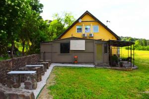 a house with benches in front of it at Pilikán Apartments - Park, Market, Vineyard & Sheep farm in Cserszegtomaj