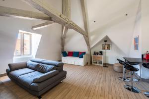 a living room with a couch and a table at Le Palais in Dijon