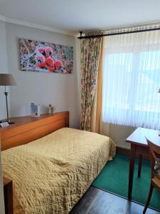 a hotel room with a bed and a window at Hotel Zur Post in Waldbreitbach