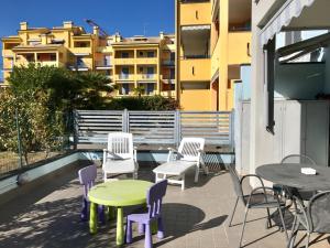 eine Terrasse mit Stühlen sowie einem Tisch, Tischen und Stühlen in der Unterkunft casa vacanza Carly in Loano