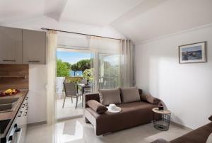 a living room with a couch and a kitchen at Estell apartments in Sykia Chalkidikis