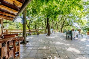 eine Terrasse mit Tischen, Stühlen und Bäumen in der Unterkunft Country House di Campo Stivaletto Nepi in Nepi