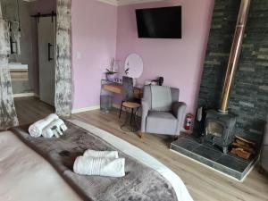 a living room with a bed and a fireplace at Mosswood Bed & Breakfast in Graskop