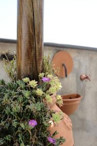un vase rempli de fleurs à côté d'un poteau en bois dans l'établissement DAME casa vacanza, à Amalfi