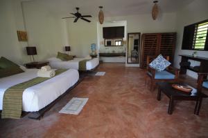 a hotel room with two beds and a fan at Sol Caribe in Punta Allen