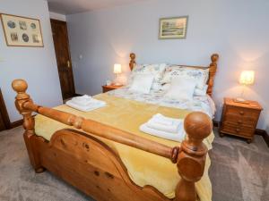 a bedroom with a large wooden bed with two night stands at 1 Netherbeck Barn in Carnforth