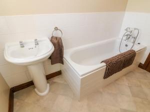 a bathroom with a sink and a bath tub at 1 Netherbeck Barn in Carnforth +26 photos