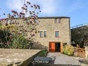 a stone house with a courtyard in front of it at 1 Netherbeck Barn in Carnforth