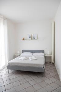 een witte slaapkamer met een bed en 2 tafels bij Casa Rubini in Teramo